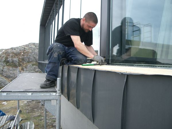 En av våre arbeidere i full sving med fasaden til den kjente restauranten på Ulrikens topp. Foto: Fana Blikk