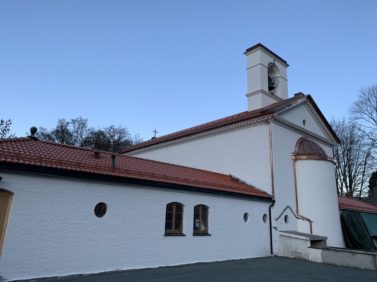 Et hvitt kirkebygg med rødt tak og nye beslag.